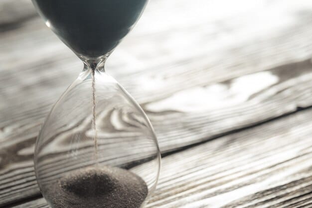 A close-up shot of an hourglass with sand running out, symbolizing the urgency of grant application deadlines. The background is blurred to keep the focus on the hourglass.