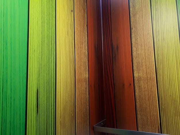 A close-up shot of a textured wall made from natural wood panels. The wood grain is visible, and the texture is tactile and inviting. Soft, diffused light highlights the natural variations in the wood.