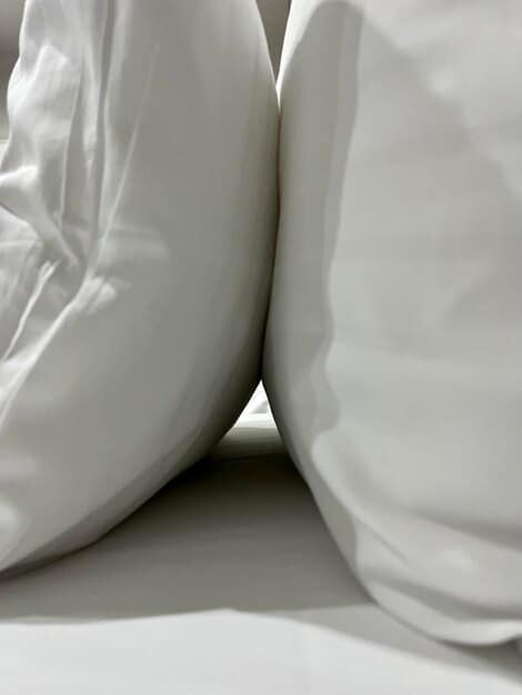 A close-up of luxurious and comfortable bedding, including a plush mattress, soft pillows, and smooth sheets. The image emphasizes the importance of quality bedding for a good night's sleep.