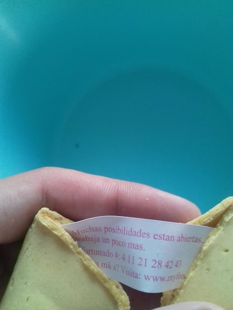 Close-up of a nutrition label on a processed food item, highlighting the sodium content. The label is contrasted with a hand reaching for fresh vegetables in the background.
