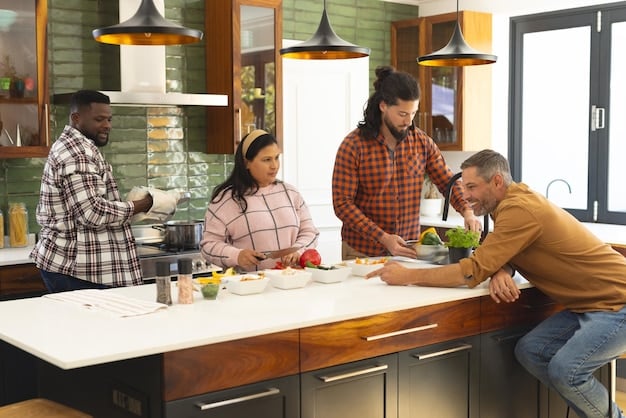 A well-equipped, modern shared kitchen in a co-living space. Several people are cooking and interacting, showcasing the communal aspect of meal preparation. The kitchen features stainless steel appliances, ample counter space, and storage options.