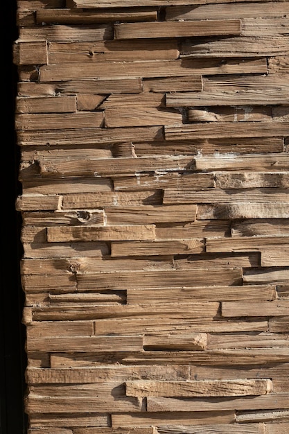 A close-up of a wall constructed with reclaimed wood, showcasing the texture and character of the material.