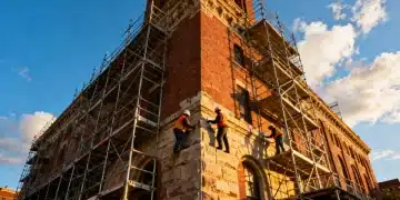 Historic building under renovation with scaffolding and workers
